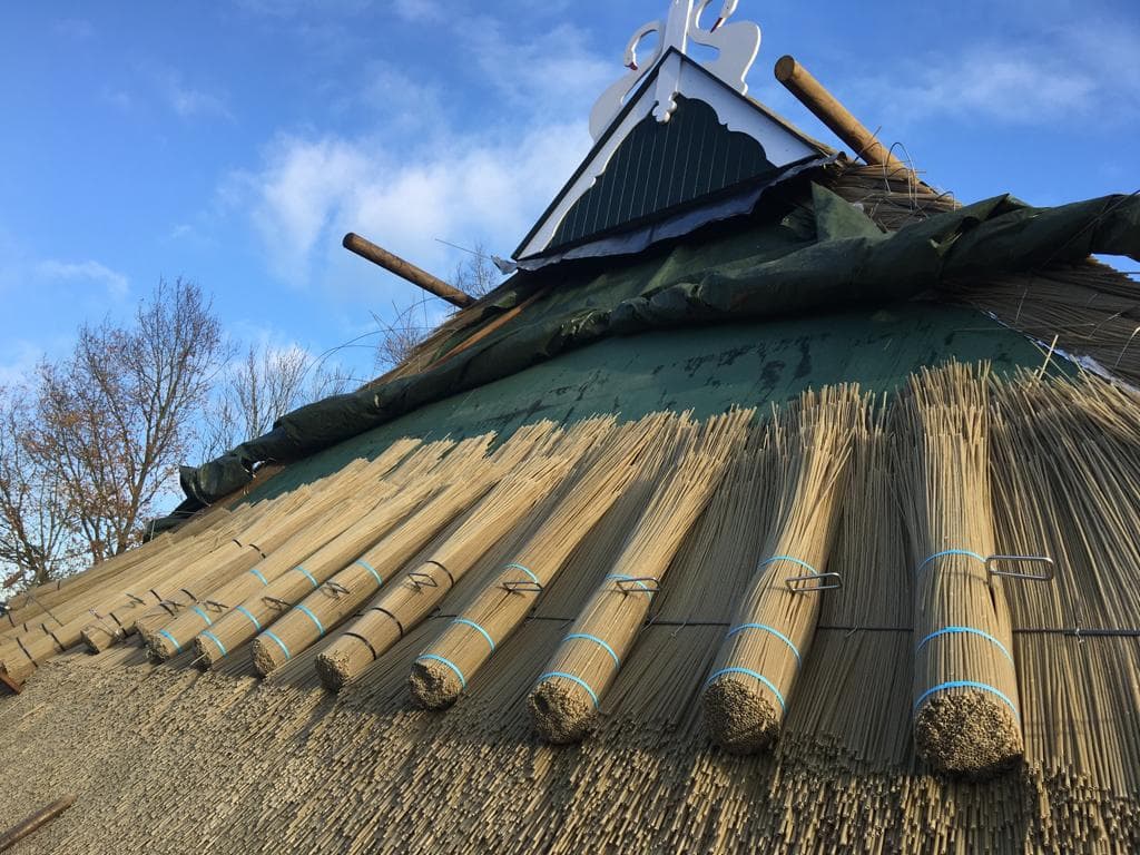 Kunstrietbundels tijdens het dekken van een rieten dak